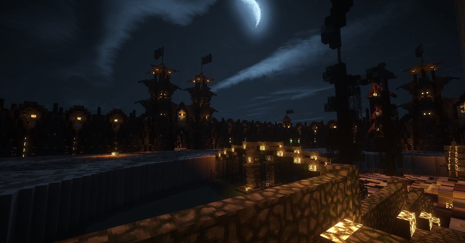 Crescent moon over castle walls and lantern-lit towers at night