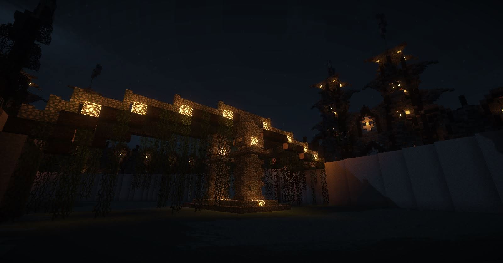 Glowstone-lit stone arch draped in vines at night